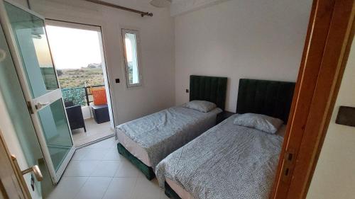 Ένα ή περισσότερα κρεβάτια σε δωμάτιο στο Appartement avec piscines, vue sur mer et accès à la plage à Achakar Hill, Tanger.