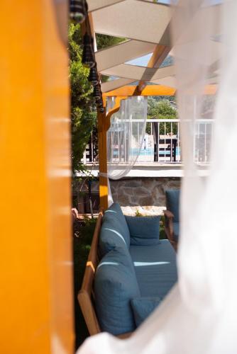 a blue couch sitting under a patio umbrella at Mavi Yaprak Hotel in Oludeniz