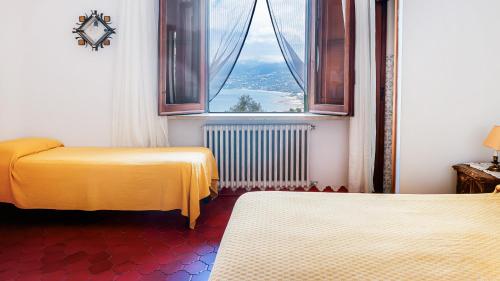 a room with two beds and a large window at B&B Dolce Sosta in Palinuro