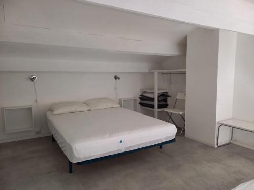 une chambre blanche avec un lit et un bureau dans l'établissement Studio mezzanine 32 m2 Port La Nouvelle Quartier des Lacs proche plage, à Port-la-Nouvelle