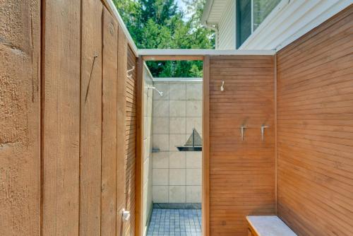 a bathroom with a shower with wooden walls at Narragansett Vacation Rental Near River and Beach! in Narragansett