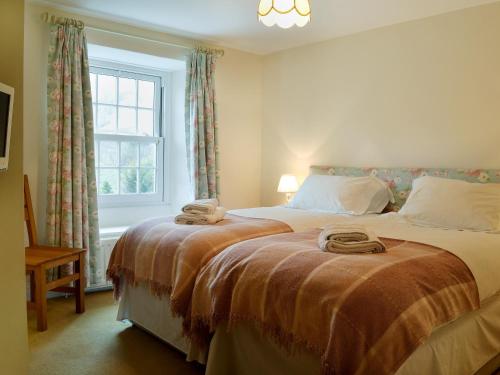 1 dormitorio con 2 camas y ventana en Fellmere en Ambleside