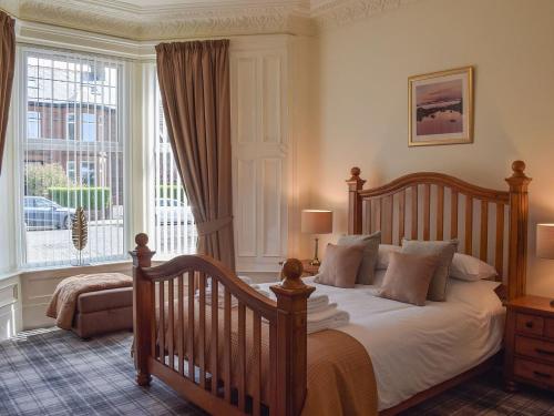um quarto com uma cama e uma grande janela em Sorbie Villa em Stevenston