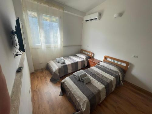 Habitación con 2 camas y TV. en Agrimar, en Magliano Romano