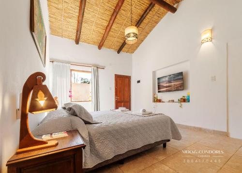 1 dormitorio con 1 cama y 1 mesa con lámpara en Nido de cóndores en Purmamarca