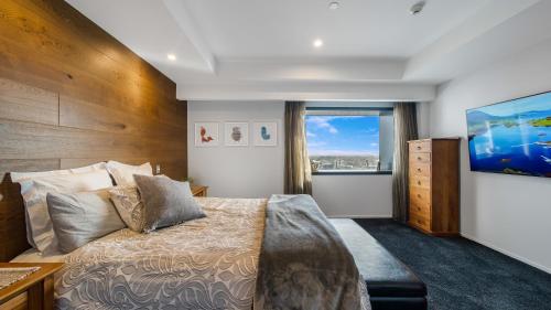 a bedroom with a large bed and a large window at Central City View with Free Valet Parking in Christchurch