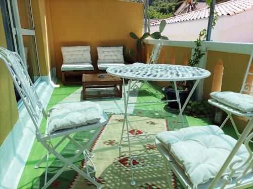 een patio met een tafel en stoelen op een balkon bij Beautiful Vintage House in Vis