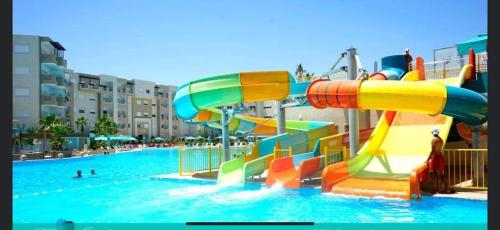 a water park with a slide in the water at A Luxury 2BR with Big Pools Perfect for Family Summer Escape! in Monastir