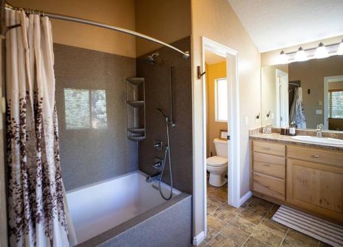 a bathroom with a shower and a toilet and a sink at Aspen Glow Lodge ~ Luxury Cabin in Duck Creek in Duck Creek Village