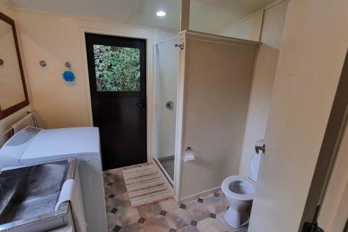 a small bathroom with a shower and a toilet at Country Retreat in Cooks Beach