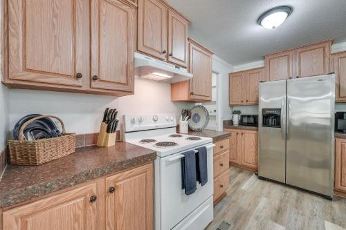 a kitchen with wooden cabinets and a white refrigerator at Fire Pit and Stunning Lake Views Shell Knob Home! in Shell Knob