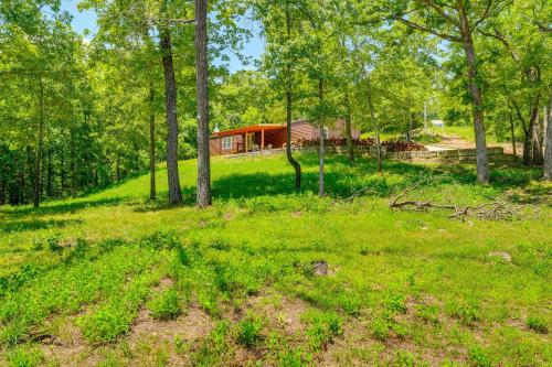 a house in the middle of a field with trees at Fire Pit and Stunning Lake Views Shell Knob Home! in Shell Knob
