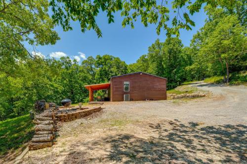 a cabin in the woods next to a dirt road at Fire Pit and Stunning Lake Views Shell Knob Home! in Shell Knob