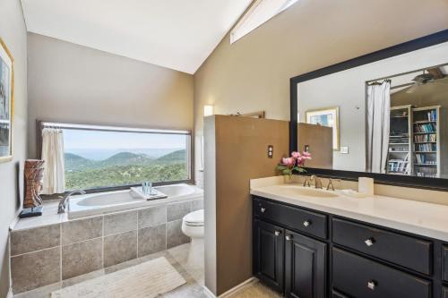 baño con lavabo y aseo y ventana en Pipe Creek Escape with Screened-In Porch and Hot Tub!, en Pipe Creek