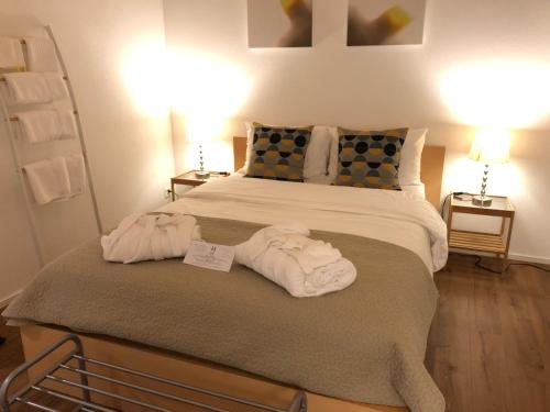 1 dormitorio con 1 cama con toallas en Dorf Hotel "Zuhause in Lachen" en Lachen