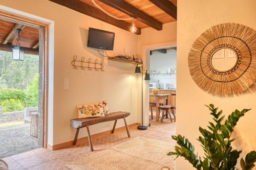 a living room with a bench and a tv at Chalet da Nogueira, a Home in Madeira in Ponta do Sol