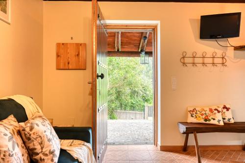 a living room with a door leading to a yard at Chalet da Nogueira, a Home in Madeira in Ponta do Sol