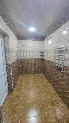 an empty bathroom with a tiled room with a shower at Qafqaz Flower Villa in Gabala