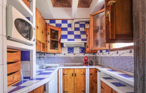 uma cozinha com armários de madeira e azulejos azuis e brancos em Beautiful Apartment In Torremolinos With Kitchen em Torremolinos