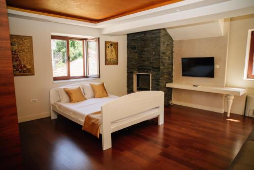 a bedroom with a white bed and a fireplace at Filip Deluxe Rooms in Kotor