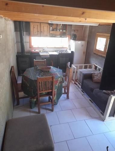 a kitchen and living room with a table and a couch at Rancho express in San Martín de los Andes