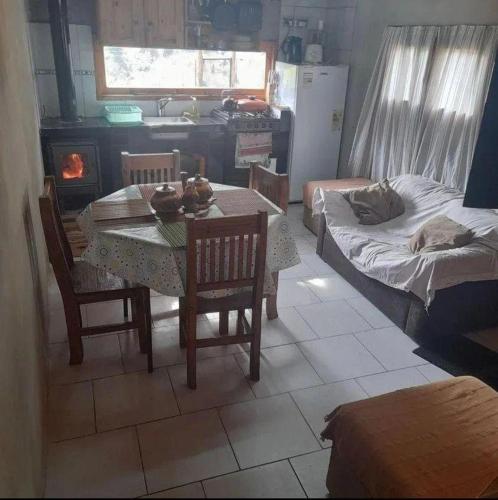 a living room with a table and a bed and a kitchen at Rancho express in San Martín de los Andes