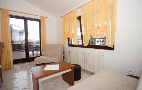 a room with a bed and a chair and a table at 2 Bedroom Gorgeous Apartment In Podstrana in Podstrana
