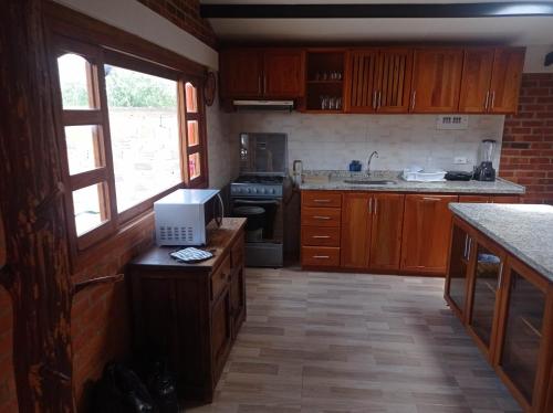 cocina con armarios de madera y encimera con microondas en Villa Almafe, en Villa de Leyva