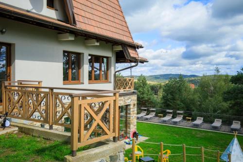 a house with a wooden deck and a yard at KATUN Apartmani & SPA in Divčibare