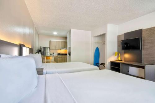a hotel room with two beds and a flat screen tv at Studio 6-San Antonio, TX - Six Flags in San Antonio