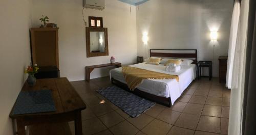a bedroom with a bed and a table and a mirror at Posada Arigalan in Mazunte