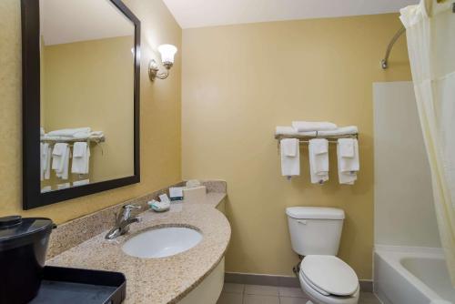 a bathroom with a sink and a toilet and a mirror at Quality Inn & Suites Chambersburg in Chambersburg