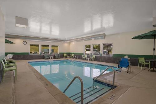 a large swimming pool with chairs and a table at Quality Inn & Suites Chambersburg in Chambersburg