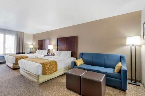 une chambre d'hôtel avec deux lits et un canapé bleu dans l'établissement Comfort Inn & Suites Mitchell I-90, à Mitchell