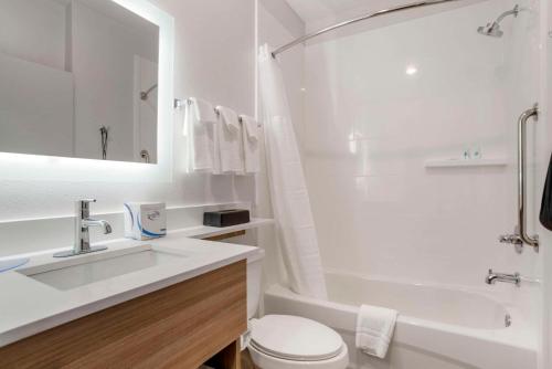 ein weißes Badezimmer mit einem Waschbecken, einer Badewanne und einem WC in der Unterkunft Comfort Inn & Suites Destin near Henderson Beach in Destin