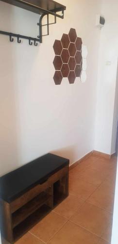 um banco sentado numa sala com uma parede branca em Apartament fabryczny Comfort em Pisz