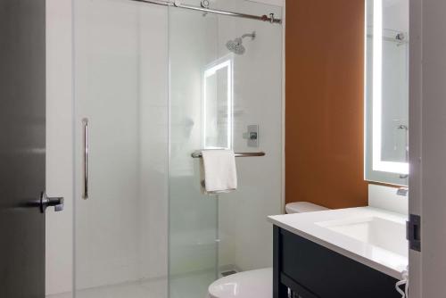 a bathroom with a glass shower and a sink at Sleep Inn in Erie