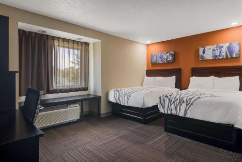 ein Hotelzimmer mit 2 Betten und einem Fenster in der Unterkunft Sleep Inn in Erie