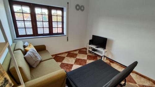 sala de estar con sofá y TV en Li-miana Alojamento Local, en Ponte de Lima