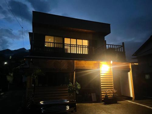 a house at night with the sun shining on it at ATASHIKADAYS Kumano-Kodo Beachfront B&B Hostel in Kumano