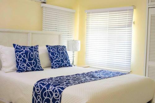 a bedroom with a bed with blue and white pillows at Villa Paradiso in Richmond