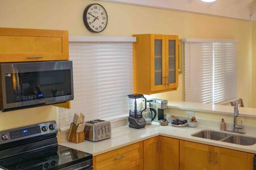 a kitchen with a counter top with a clock on the wall at Villa Paradiso in Richmond