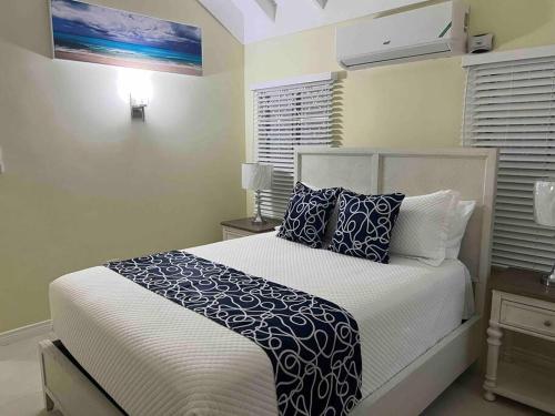 a bedroom with a bed with blue and white pillows at Villa Paradiso in Richmond