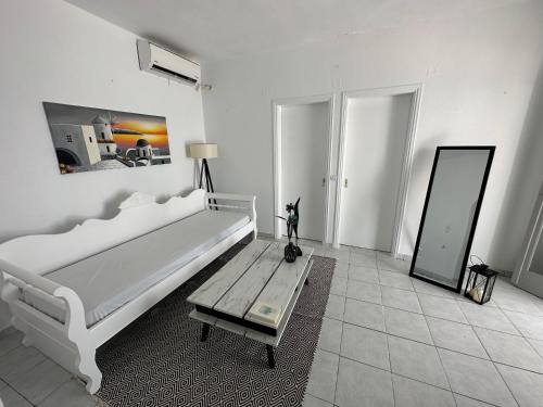 Un dormitorio blanco con una cama grande y una mesa en Santorini Grace Villa 3 en Foinikiá