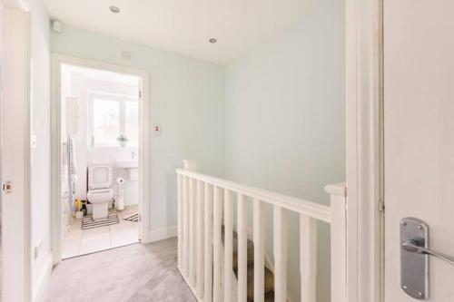 a white room with a staircase and a hallway at Overbury Lodge, Birmingham with FREE Parking in Northfield