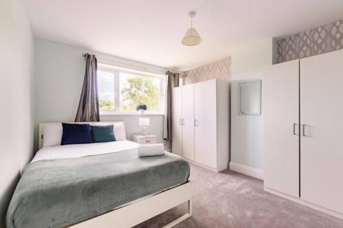 a bedroom with a large bed and a window at Overbury Lodge, Birmingham with FREE Parking in Northfield