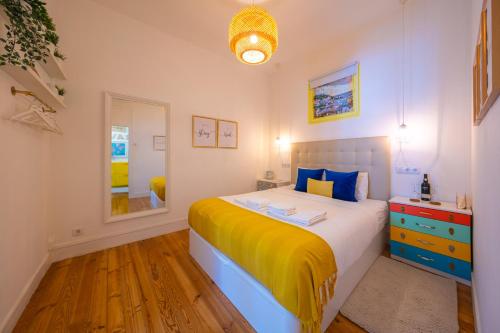 ein kleines Schlafzimmer mit einem Bett und einem Spiegel in der Unterkunft Wanderful Home - Travel Themed Apartment in Lissabon