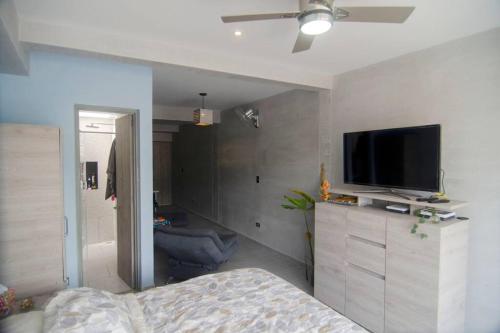 a bedroom with a bed and a flat screen tv at Design Studio Apartment with balcony and view in central and quiet area in Cali
