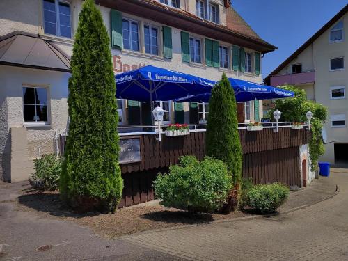 a building with a blue umbrella and some bushes at Hotel "Cafe Verkehrt" - Wellcome Motorbiker, Berufsleute und Reisende im Schwarzwald in Oberhof