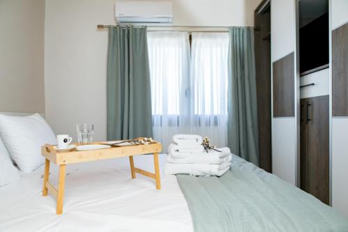 a bedroom with a bed and a table with towels at Four Princess in Agia Paraskevi